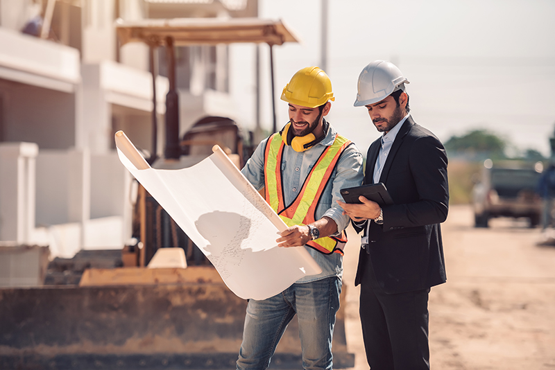 Civil engineer and construction worker manager holding digital t